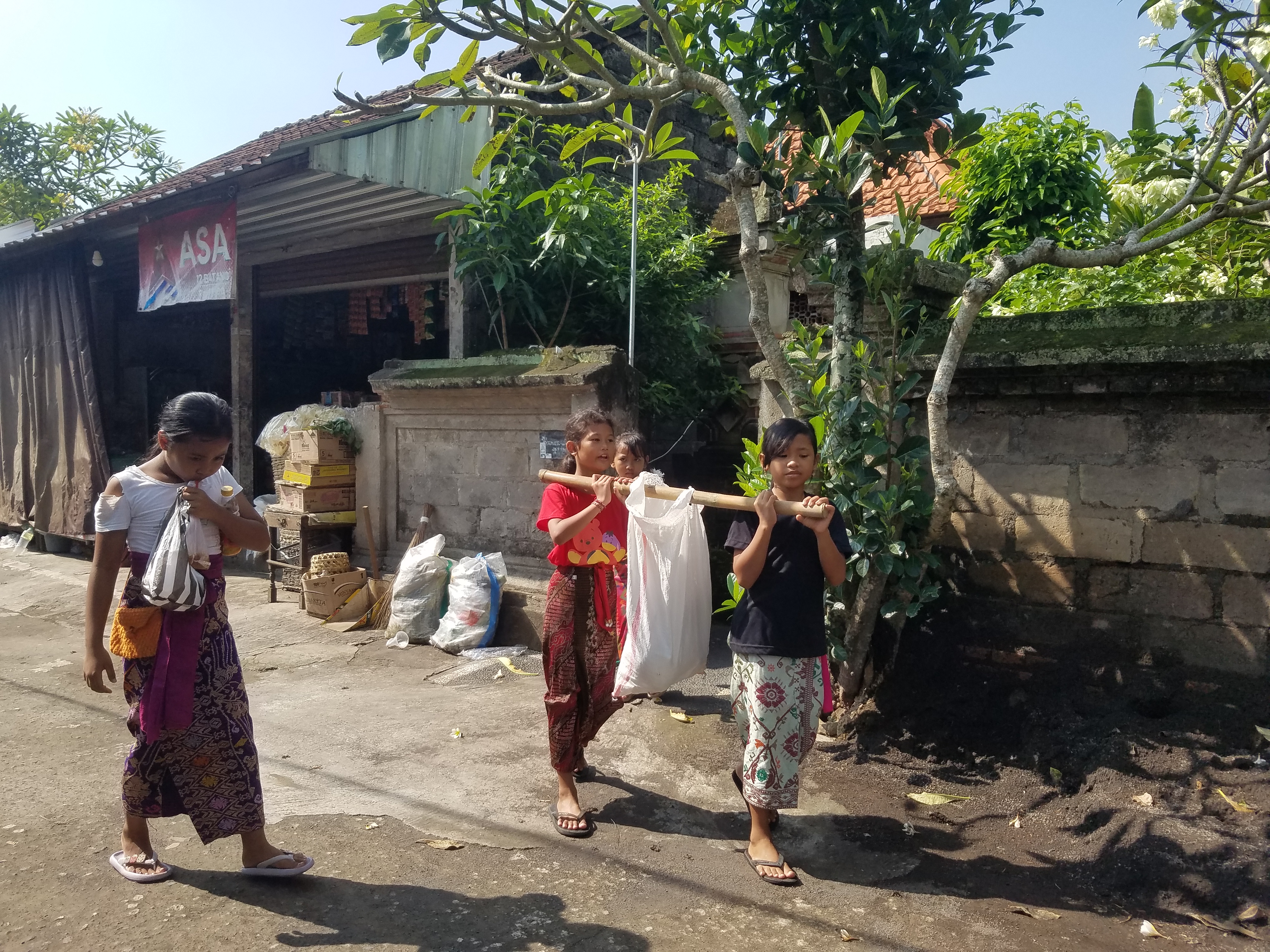 Anak-anak berjalan menuju rumah warga