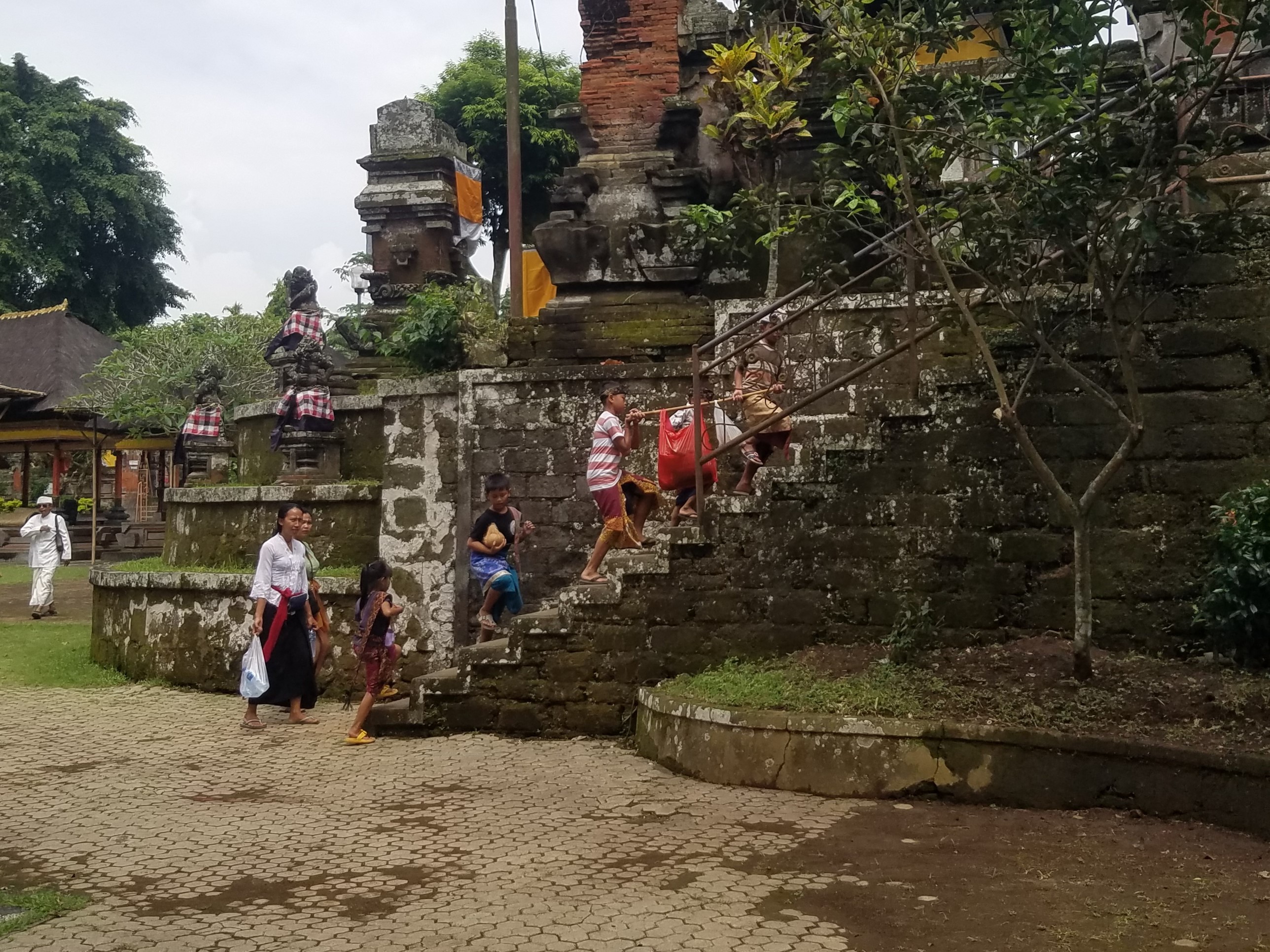 Anak-anak membawa hasil ambengan ke Pura Samuan Tiga